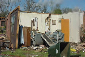 A mobile home with the roof gone and walls collapsed
